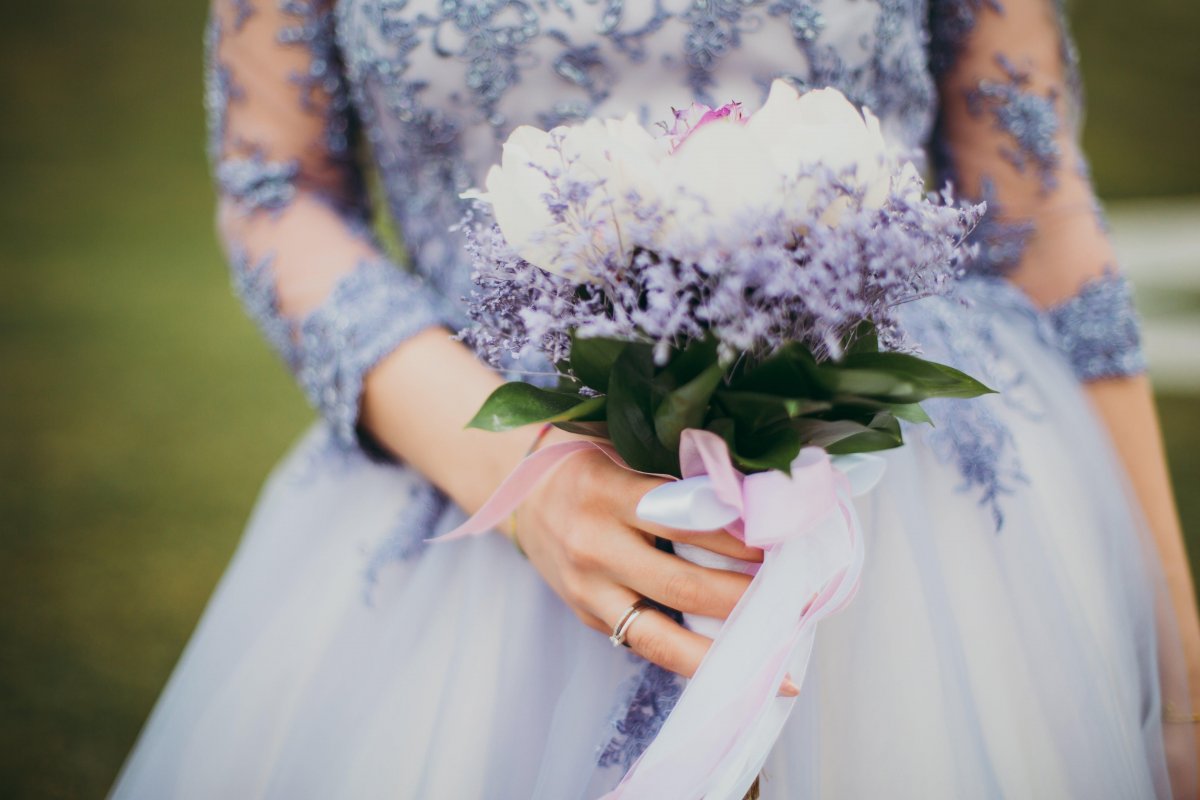 Woman in Blue Gown Holding Bouquet of Flowers