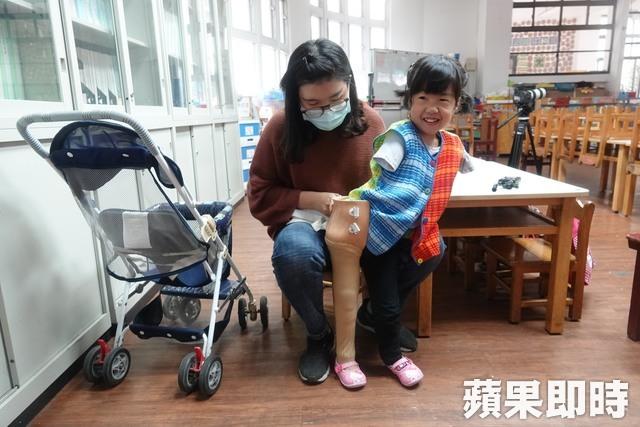 幼兒園老師協助又立穿上義肢。戴之聖攝