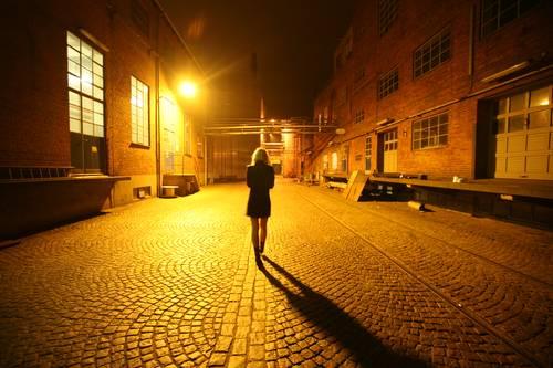 Woman Walking on Street at Night